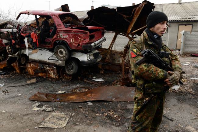 <YONHAP PHOTO-2021> Armed supporter of self-proclamed People's Republic of Donetsk stands on the street among the destroyed houses and cars in the airport area in eastern Ukrainian city of Donetsk on December 16, 2014. AFP PHOTO / VASILY MAXIMOV../2014-12-16 22:00:47/ <저작권자 ⓒ 1980-2014 ㈜연합뉴스. 무단 전재 재배포 금지.>
An armed supporter of self-proclamed People’s Republic of Donetsk stands in a street among destroyed houses and cars in the airport area in the eastern Ukrainian city of Donetsk on Tuesday.   AFP-Yonhap