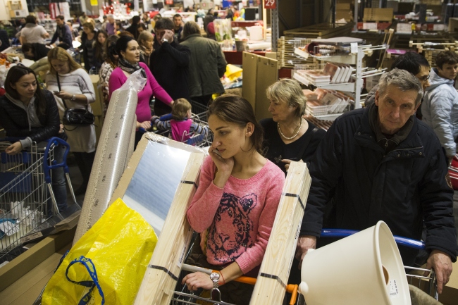 <YONHAP PHOTO-2625> People wait in a line to pay for her purchases at the IKEA store on the outskirts of Moscow, Russia, Wednesday, Dec. 17, 2014. The collapse of the national currency triggered a spending spree by Russians desperate to buy cars and home appliances before prices shoot higher. Several car dealership were reported to have suspended sales, unsure how far down the ruble will go, while Apple halted all online sales in Russia. (AP Photo/Pavel Golovkin)/2014-12-17 23:28:10/ <저작권자 ⓒ 1980-2014 ㈜연합뉴스. 무단 전재 재배포 금지.>
People wait in a line to pay for their purchases at the IKEA store on the outskirts of Moscow on Wednesday.   AP-Yonhap