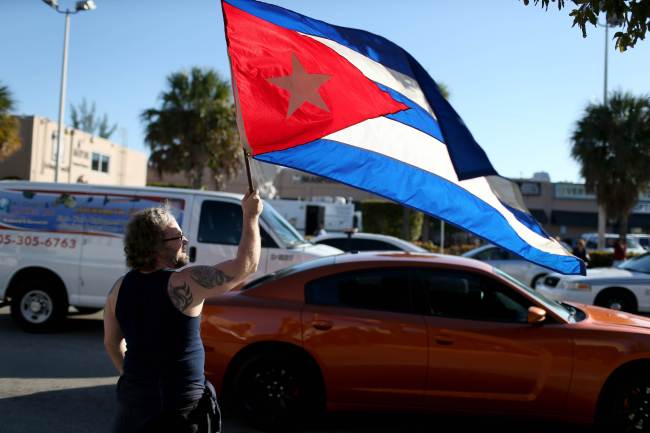 Abdel Rodriguez holds a Cuban flag as he stands outside the Little Havana restaurant Versailles in Miami, Florida, Wednesday.   AFP-Yonhap