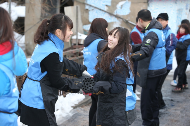 Woori Bank employees deliver coal briquettes for fuel to low-income families in Nowon-gu, Seoul, last December.   Woori Bank
