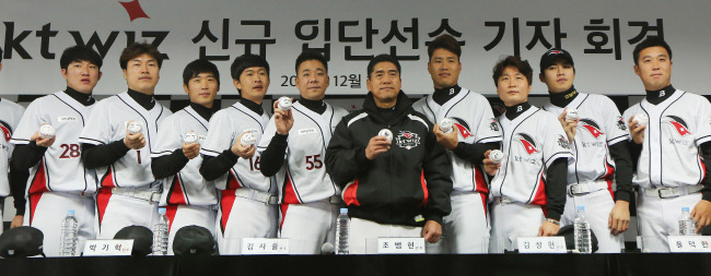 Cho Bum-hyun (fifth from right), manager of the KT Wiz baseball club, poses with the team’s offseason acquisitions during their press conference in Suwon, Gyeonggi Province, Thursday.   Yonhap