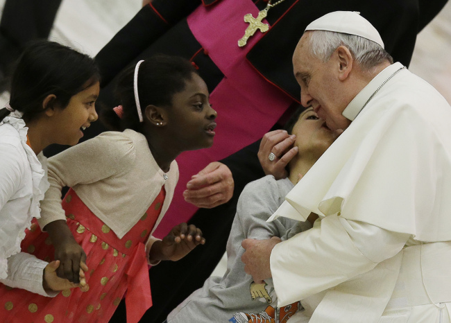 A child kisses Pope Francis (right) during a meeting with faithful of Pope John XXIII Community in the Paul VI hall at the Vatican on Saturday.   AP-Yonhap