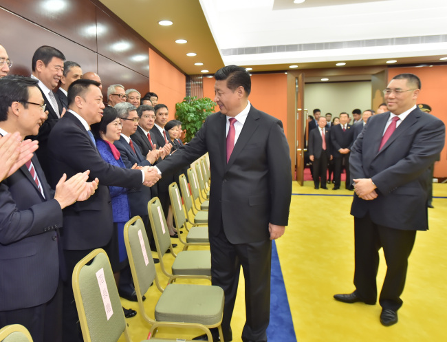 Chinese President Xi Jinping (center) meets with officials from the executive, legislative and judicial branches of the Macau Special Administrative Region in Macau, southern China, Saturday.   Xinhua-Yonhap