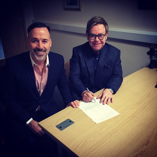 Elton John (right) and David Furnish sign a form in a photo posted on the singer’s Instagram captioned “That’s the legal bit done. Now on to the ceremony!”   Elton John Instagram