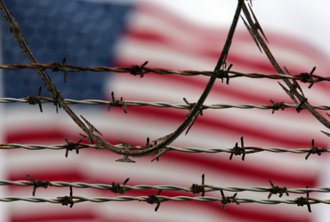 An American flag flies behind the barbed and razor-wire at the Camp Delta detention facility, at Guantanamo Bay U.S. Naval Base, Cuba.    AP-Yonhap
