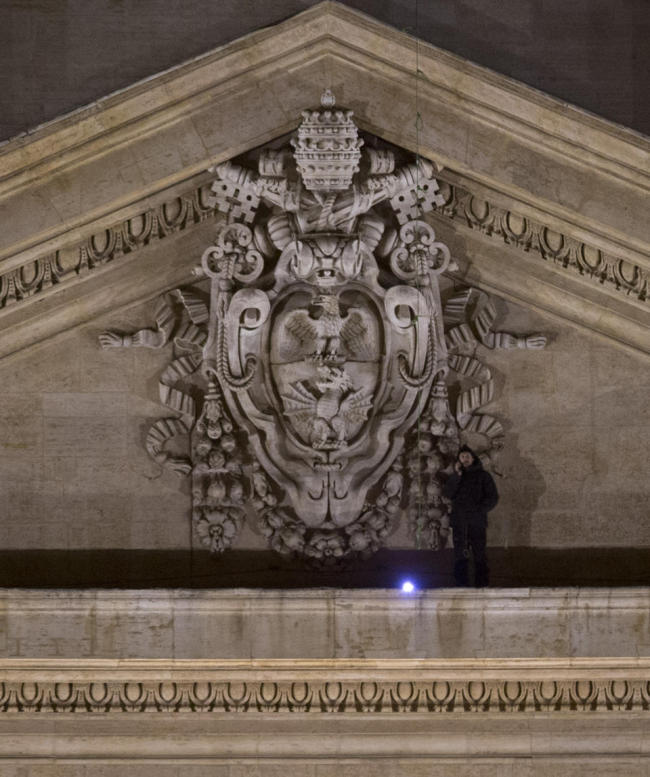 Italian entrepreneur Marcello di Finizio talks on the phone as he stands on the facade of St. Peter’s Cathedral at the Vatican, Sunday.   AP