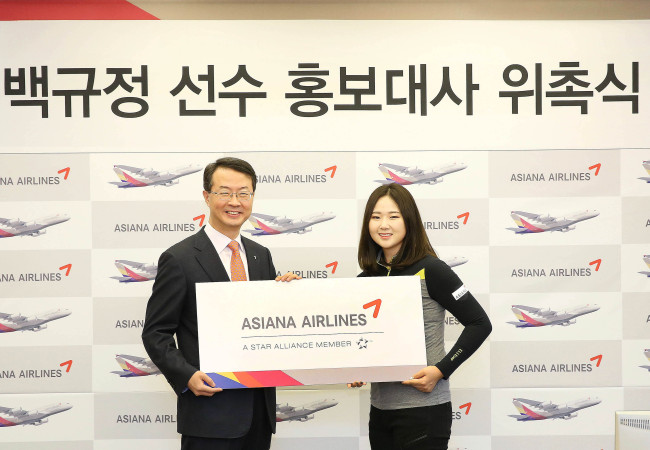 Asiana Airlines CEO Kim Soo-cheon (left) poses with pro-golfer Baek Kyu-jung after appointing her as the airline’s public relations ambassador in Seoul on Tuesday.   Asiana Airlines