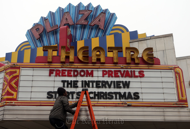 Brandon Delaney, general manager of the Plaza Theatre in Atlanta, hangs the marquis Tuesday to announce that the theatre will be showing "The Interview." (AP-Yonhap)