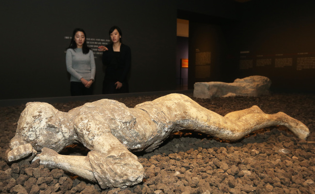 <YONHAP PHOTO-0781> '폼페이 최후의 날' (서울=연합뉴스) 홍기원 기자 = 8일 오전 서울 용산구 국립중앙박물관 기획전시실에서 열린 '로마제국의 도시문화와 폼페이'展 언론공개회에서 참석자들이 캐스트를 관람하고 있다. 오는 9일부터 내년 4월 5일까지 열리는 이번 전시에는 폼페이에서 출토된 조각품, 장신구, 벽화, 캐스트 등 298건의 다양한 유물들이 선보인다. 2014.12.8 xanadu@yna.co.kr/2014-12-08 12:47:09/ <저작권자 ⓒ 1980-2014 ㈜연합뉴스. 무단 전재 재배포 금지.>
Visitors look at a plaster cast of a victim in the National Museum of Korea’s exhibition “Pompeii: Culture of The Ancient Roman City.”   Yonhap