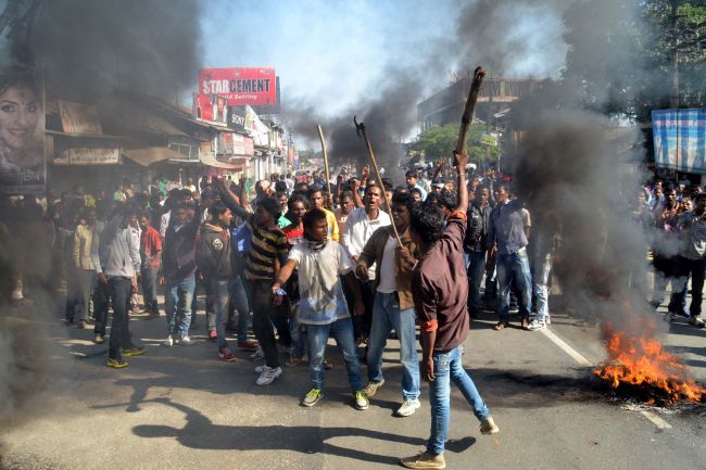 Activists of the Assam Tea Tribes Student Association shout slogans as they block the road with burning tires during a protest against attacks on villagers by militants in four different locations, at Biswanath Chariali in the Sonitpur district of Assam state, India, Wednesday.   AP-Yonhap