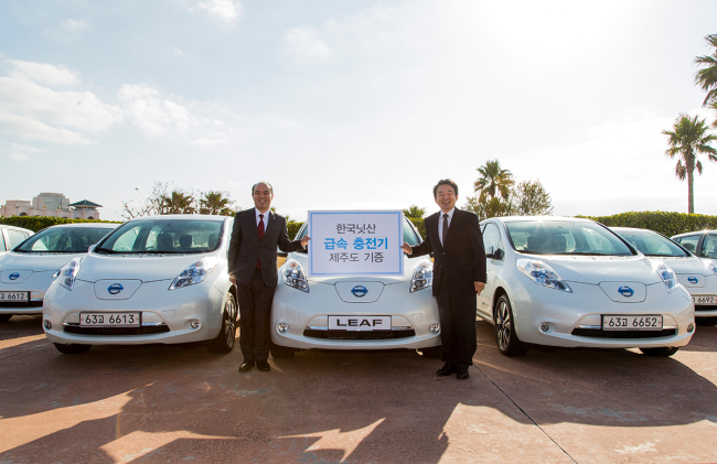 Jeju Gov. Won Hee-ryong (right) and Nissan Korea CEO Takehiko Kikuchi pose to celebrate the Nissan Leaf’s debut on the island on Tuesday.   Nissan Korea