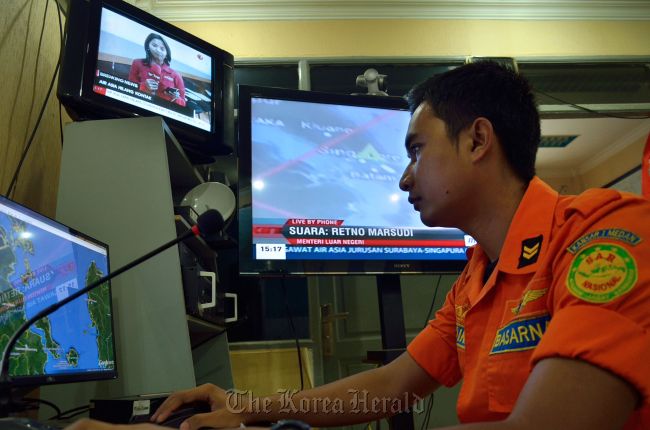 An official from Indonesia's national search and rescue agency in Medan, North Sumatra, monitors computer screens during a search efforts for AirAsia flight QZ8501 which went missing off the waters of Indonesia on Sunday. (AFP-Yonhap)