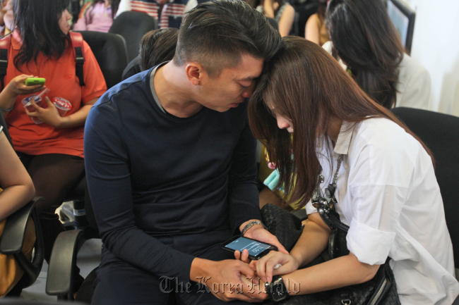 Relatives of the passengers of AirAsia flight QZ8501 comfort each other at Juanda International Airport in Surabaya, Indonesia, Sunday. (AP-Yonhap)