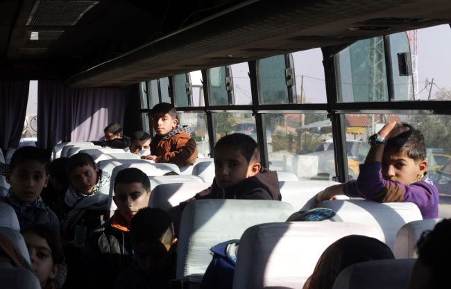 Palestinian children wait on a bus at Erez crossing in Beit Hanun in the north of the Gaza Strip on Sunday.   AFP-Yonhap