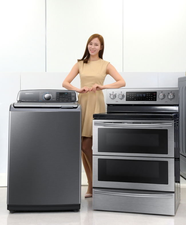 A model poses with Samsung Electronics’ washing machine and gas range, which will be displayed at the International CES in Las Vegas next week.  Samsung Electronics