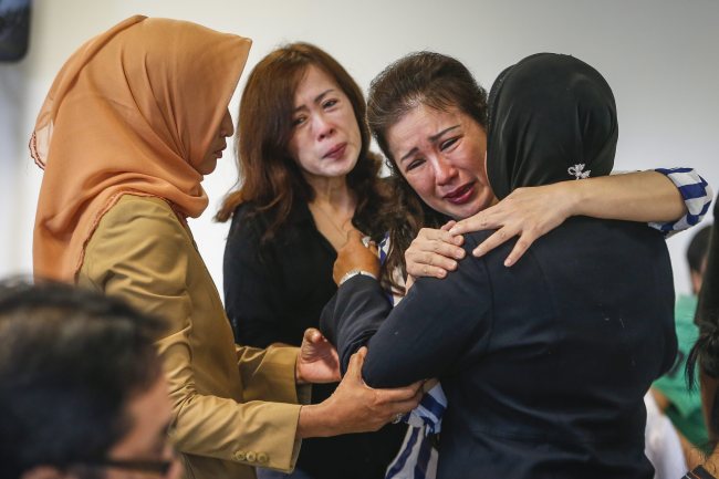 Relatives cry and comfort each other as they wait for news from the missing AirAsia plane at Juanda Airport, Indonesia. (EPA-Yonhap)