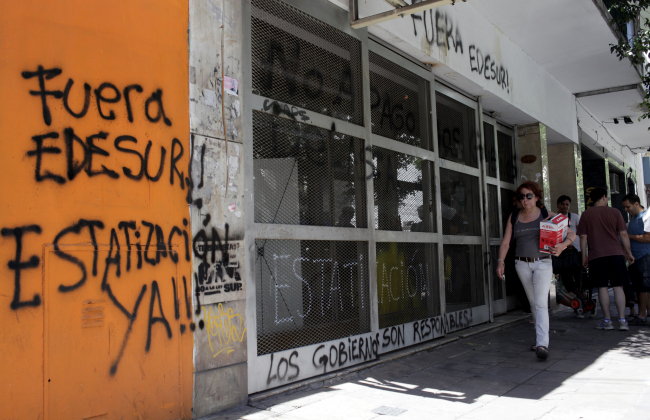 A woman walks past the closed offices in Buenos Aires, Argentina. Bloomberg
A woman walks past the closed offices in Buenos Aires, Argentina. Bloomberg