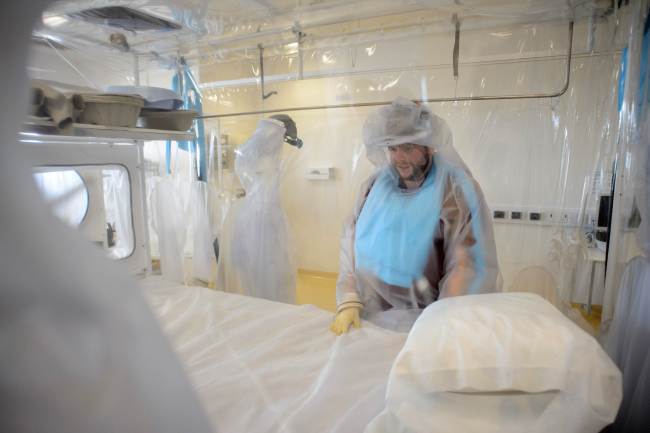 In a file picture taken on Aug. 6, 2014 a nurse wears protective clothing as he demonstrates the facilities in place at the Royal Free hospital in north London in preparation for a patient testing positive for the Ebola virus. AFP-Yonhap