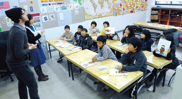 Elementary school students attend a class taught by a native English teacher.    Korea Herald file photo