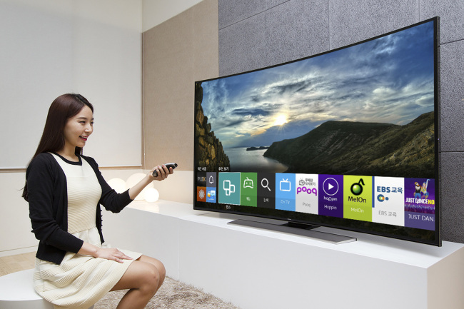 A model poses with a Samsung Electronics’ Tizen OS-based smart TV that will be unveiled at the International CES next week.   Samsung Electronics