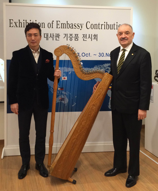 Paraguayan Ambassador to Korea Ceferino Valdez Peralta (right) donates a Paraguayan traditional harp to the Multicultural Museum of Seoul director Kim Yun-tae on Dec. 26, to commemorate the 50th anniversary of Korean immigration to Paraguay.   Paraguayan Embassy