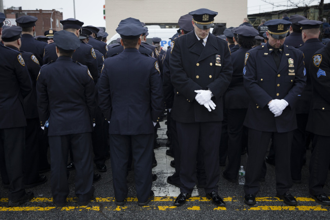 Some police officers turn their backs in a sign of disrespect as Mayor Bill de Blasio speaks as others, stand at attention during the funeral of New York Police Department Officer Wenjian Liu at Aievoli Funeral Home in the Brooklyn borough of New York on Sunday.   AP-Yonhap