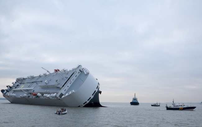 Small boats sail round the Hoegh Osaka car transporter cargo ship that ran aground off the Isle of Wight, England, Sunday. The crew members of the Hoegh Osaka were taken to safety by a coastguard helicopter and lifeboats.   AP-Yonhap