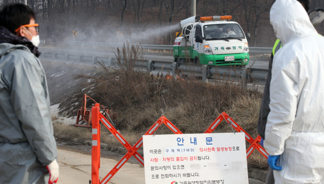 Quarantine officials restrict access to a pig farm where a suspected case of foot-and-mouth disease was detected in Yongin, Gyeonggi Province, Monday.   Yonhap