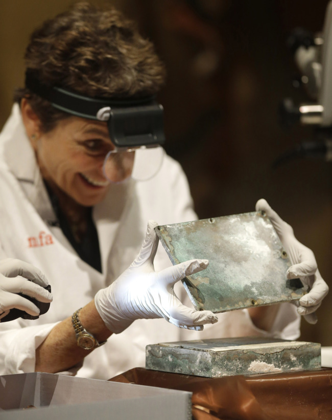 Museum of Fine Arts Boston head of objects conservation Pam Hatchfield removes a metal lid from a time capsule at the museum on Tuesday in Boston.   AP-Yonhap