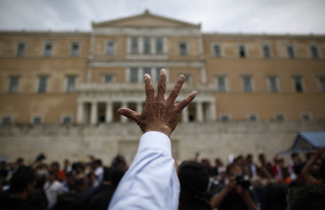 A protestor gestures during a demonstration in front of the Greek Parliament building in Athens on May 5, 2010. Bloomberg