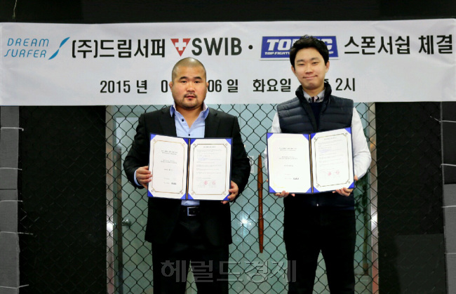 하동진 탑FC 공동대표(왼쪽)가 메인스폰서 계약을 맺은 드림서퍼 이동찬 대표와 계약서를 들어보이며 포즈를 취하고 있다.