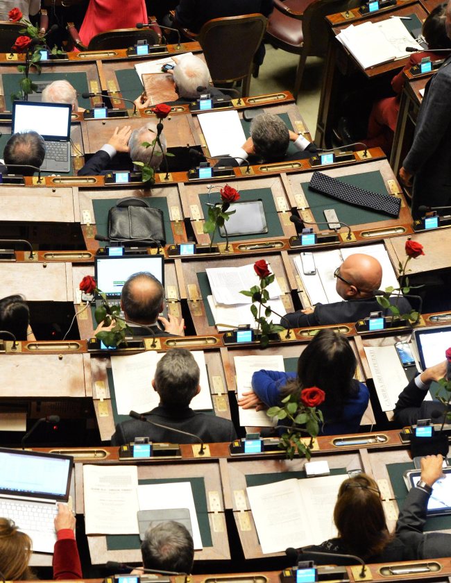 Deputies of Italian party Scelta Civica place roses on their desks in memory of the victims of the attack on the controversial French magazine Charlie Hebdo, during a vote on amendments to the draft constitutional law, Montecitorio, Rome, Thursday.     EPA-Yonhap