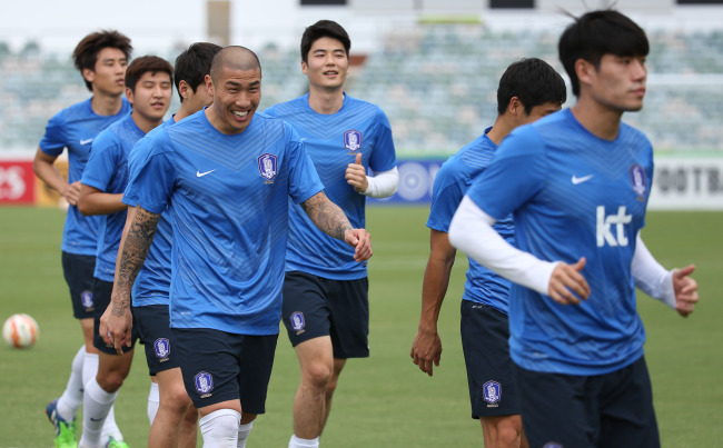Korean football players warm up during the training session at Canberra Stadium in Australia. Korea’s first match against Oman will kick off on Saturday.   Yonhap