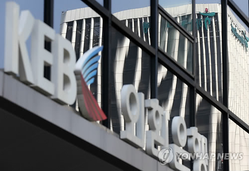 The Hana Financial Group building reflected in the window of a KEB office in Seoul.   Yonhap