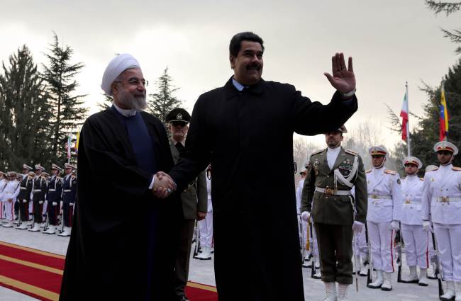 Iranian President Hassan Rouhani (left) shakes hands with Venezuelan President Nicolas Maduro after reviewing the honor guard at the Saadabad Palace in Tehran on Saturday.   AFP-Yonhap