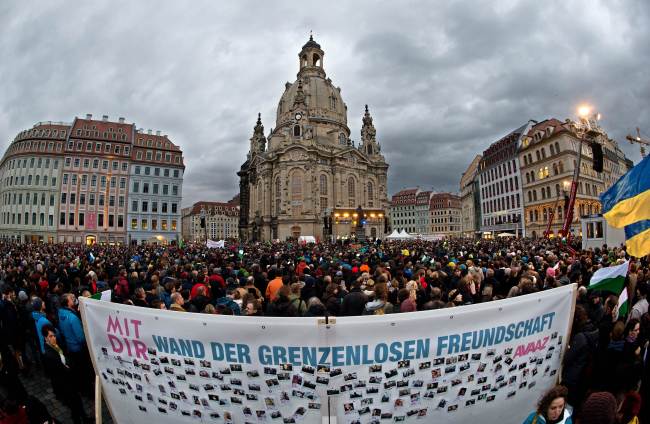 A banner reading”Wall of friendship without borders” can be seen in the foreground as thousands of people take part in a rally themed”For Dresden, for Saxony ― living together in the sense of a global awareness, humanity and dialogue” in front of the Frauenkirche (Church of Our Lady) in Dresden, eastern Germany, Saturday.   AFP-Yonhap