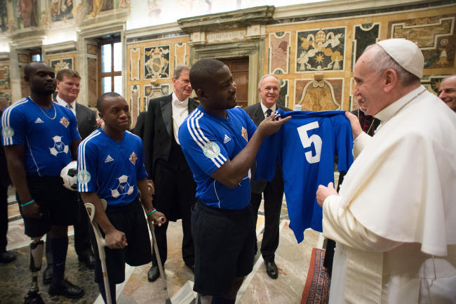 Pope Francis is presented with a soccer jersey as he meets with participants of the meeting organized by the pontifical council Cor Unum and the Pontifical Commission for Latin America on the fifth anniversary of Haiti’s earthquake during a private audience at the Vatican, Saturday.   AP-Yonhap