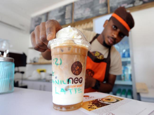 A steward prepares iced coffee for a customer at Cafe Neo in Lagos. (AFP)