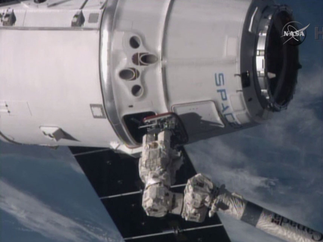 The International Space Station’s robotic arm reaches for the SpaceX Dragon spacecraft.   AP-Yonhap