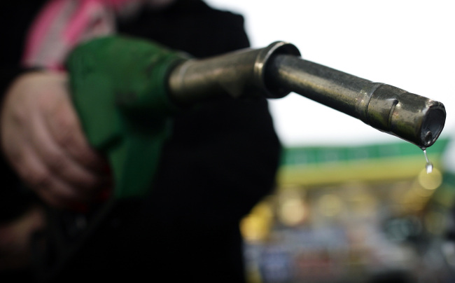 A customer removes a fuel pump from its holder at a BP gas station in London.   Bloomberg