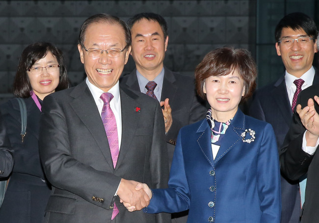Education Minister Hwang Woo-yea (left) shakes hands with Choi Kyung-hee, the president of Ewha Womans University, during his visit to the university campus in Seoul on Wednesday.   Yonhap
