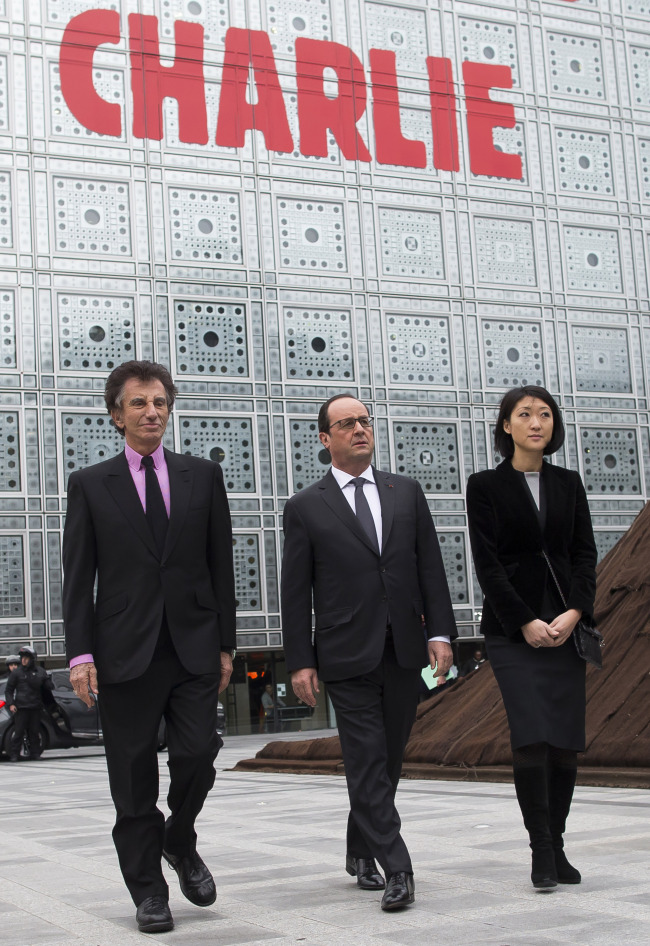 French President Francois Hollande (center), Culture Minister Fleur Pellerin (right) and Institut du Monde Arabe President Jack Lang pose for photos at the Arab World Institute in Paris on Thursday.   AP-Yonhap