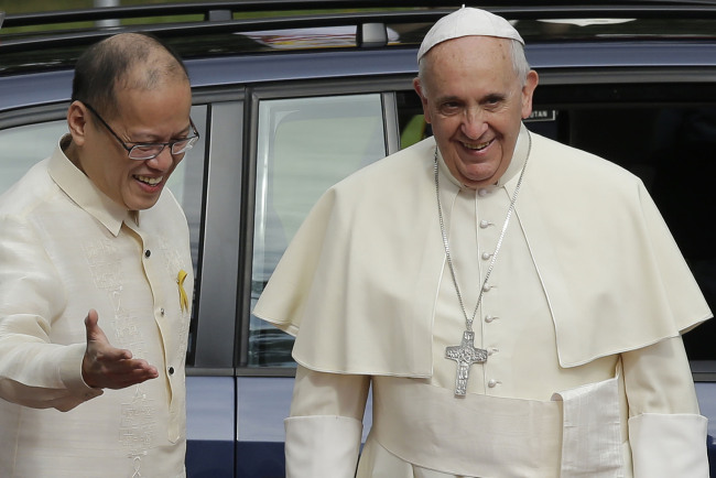 Pope Francis (right) is welcomed by Philippine President Benigno Aquino III as he arrives for the welcoming ceremony at the Presidential Palace grounds in Manila, the Philippines, Friday.   AP-Yonhap