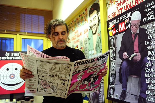 The director of the satirical Turkish magazine Leman, Zafer Aknar, looks at an issue of the French satirical weekly Charlie Hebdo in Istanbul. AFP-Yonhap