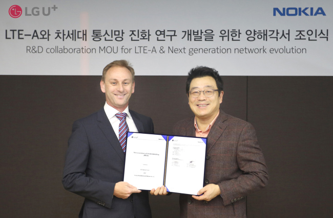LG Uplus executive vice president Kim Sun-tae (right) and Andrew Cope, head of Nokia Networks’ Korean office, pose after signing an MOU for R&D collaboration for the fifth generation networks.   LG Uplus