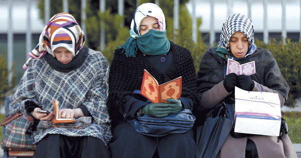 Supporters of the Fethullah Gulen Movement read the Quran as they wait outside a courthouse in Istanbul, Turkey. (EPA-Yonhap)