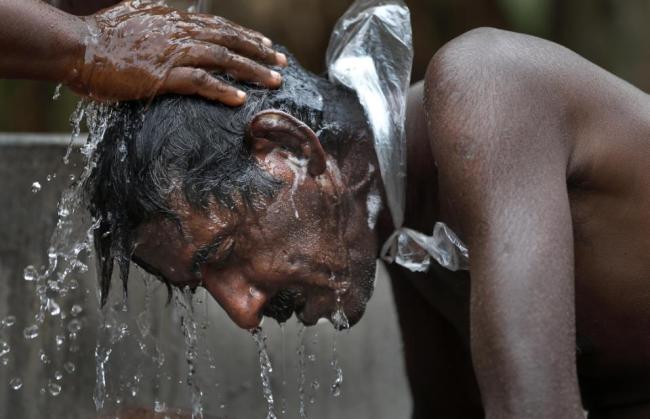A farmer suffering from chronic kidney disease bathes in Medavachchiya, Sri Lanka.   AP
