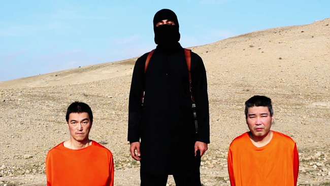This image taken from an online video released by the Islamic State group, purports to show the group threatening to kill two Japanese hostages that the militants identify as Kenji Goto Jogo (left) and Haruna Yukawa (right), unless a $200 million ransom is paid within 72 hours.    AP-Yonhap