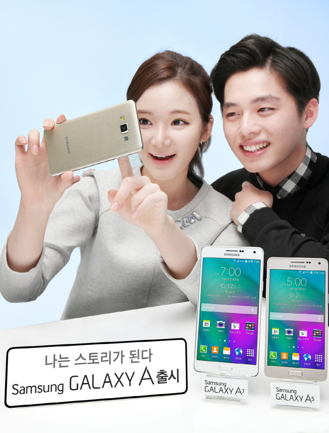 Models pose with Samsung’s mid-range Galaxy A5 and Galaxy A7 smartphones, featuring metal, ultra-slim bodies, which will be on sale from Thursday.   Samsung Electronics
