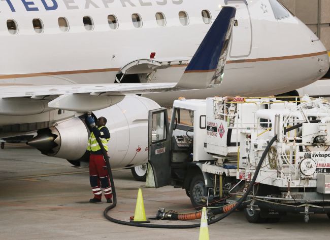 A worker prepares to fuel a United Express aircraft after it arrived at Dallas-Fort Worth International Airport in Grapevine, Texas.    AP-Yonhap